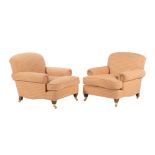 A pair of upholstered armchairs in the manner of George Smith