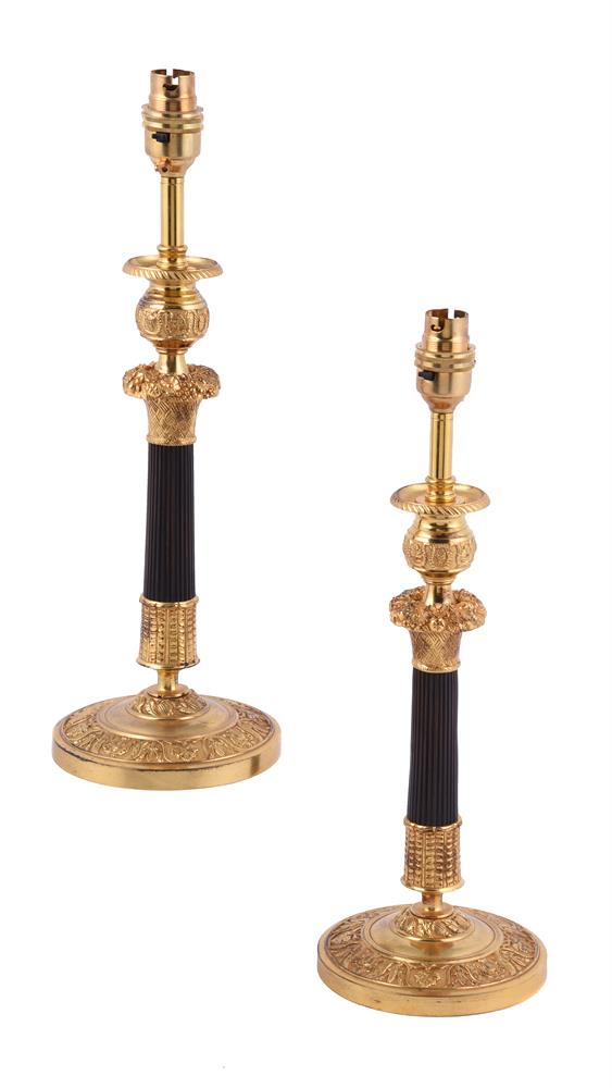 A pair of gilt and patinated metal candlesticks