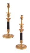 A pair of gilt and patinated metal candlesticks