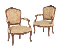A pair of carved walnut armchairs in Louis XV style