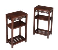 A pair of Chinese hardwood three tier occasional tables or stands