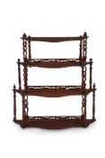 A flight of early Victorian mahogany serpentine hanging wall shelves