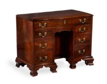 A George III mahogany and inlaid serpentine kneehole desk