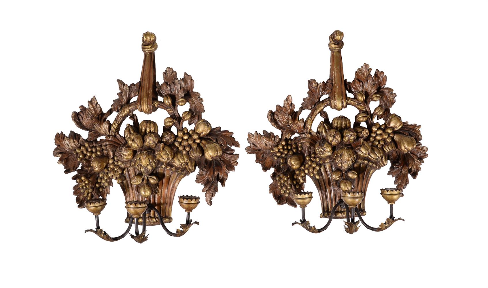 A pair of carved and giltwood three light wall appliques in 18th century taste