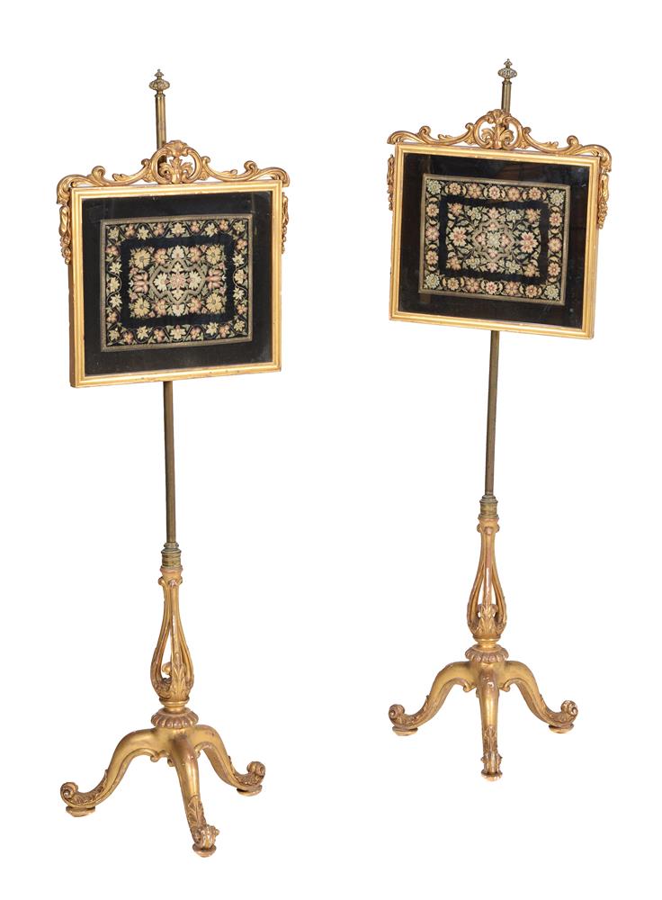 A pair of Victorian giltwood and needlework inset pole screens