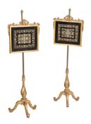 A pair of Victorian giltwood and needlework inset pole screens