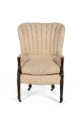 A mahogany and upholstered wing armchair in George III style