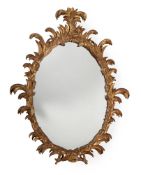 A carved giltwood oval wall mirror in George III style