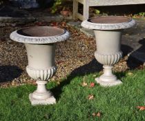 A pair of cream painted cast iron garden urns