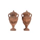 A pair of terracotta twin handled baluster urns and covers, in Italian Baroque taste