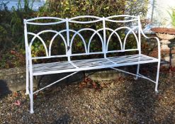 A white painted wrought iron garden bench