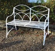 A white painted wrought iron garden bench