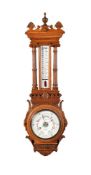 A VICTORIAN CARVED OAK AND WALNUT ANEROID WHEEL BAROMETER