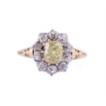 A DIAMOND AND YELLOW DIAMOND CLUSTER RINGThe rectangular cushion cut yellow diamond weighing 1.43 c