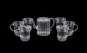 A CLEAR GLASS INTERNALLY FLUTED CYLINDRICAL TEAPOT WITH AURICULAR HANDLE, MARIAGE FRERES