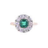 AN EMERALD AND DIAMOND CLUSTER RING