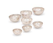 SEVEN SILVER CURVE PATTERN NESTING BOWLS, ADRIAN K. A. HOPE