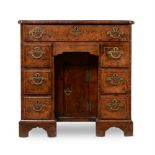 A GEORGE I BURR WALNUT AND FEATHERBANDED KNEEHOLE DESKCIRCA 1720The top with re-entrant front corn