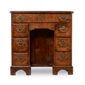 A GEORGE I BURR WALNUT AND FEATHERBANDED KNEEHOLE DESKCIRCA 1720The top with re-entrant front corn