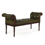 A MAHOGANY AND BUTTONED GREEN LEATHER UPHOLSTERED STOOL OR WINDOW SEAT, IN GEORGE III STYLE