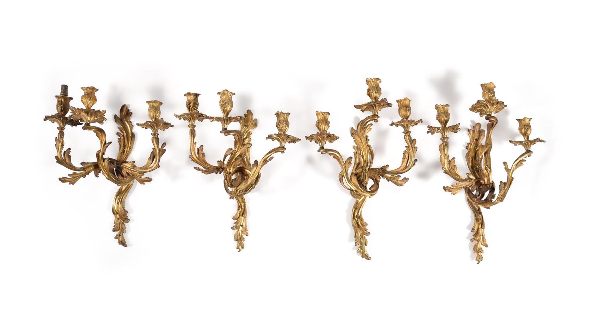 A SET OF FOUR LOUIS XV GILT METAL THREE LIGHT WALL APPLIQUES, MID 18TH CENTURY