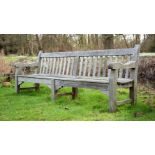 A LARGE WEATHERED HARDWOOD GARDEN BENCH, IN THE MANNER OF R. A. LISTER, 20TH CENTURY