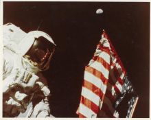 Portrait of Harrison Schmitt with the Earth above the deployed US flag, Apollo 17, 7-19 Dec 1972