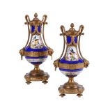 A PAIR OF SEVRES STYLE PORCELAIN AND GILT METAL MOUNTED URNS