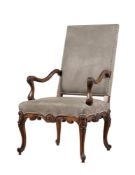 A FRENCH CARVED WALNUT AND UPHOLSTERED OPEN ARMCHAIR IN LOUIS XV STYLE
