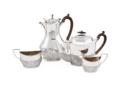 A MATCHED EDWARDIAN SILVER THREE PIECE OVAL HALF REEDED TEA SET