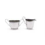 AN AMERICAN SILVER COLOURED OVAL CREAM JUG AND SUGAR BOWL