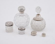 A GROUP OF SILVER MOUNTED CUT GLASS COSMETICS BOTTLES AND JARS