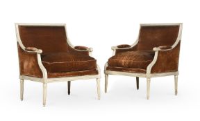 A PAIR OF LOUIS XV/XVI TRANSITIONAL CREAM PAINTED AND UPHOLSTERED BERGERE ARMCHAIRS BY SULPICE BRIZ