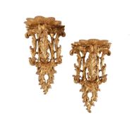 A PAIR OF CARVED GILTWOOD WALL BRACKETS, ONE GEORGE III, THE OTHER LATER