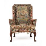 AN EARLY GEORGE II WALNUT AND NEEDLEWORK UPHOLSTERED WING ARMCHAIR, CIRCA 1730