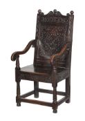 A CHARLES II CARVED OAK PANEL BACK ARMCHAIR, POSSIBLY YORKSHIRE, CIRCA 1660