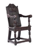 A CHARLES I CARVED OAK PANEL BACK OPEN ARMCHAIR