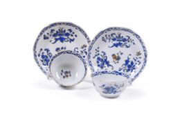An unusual pair of Chinese porcelain blue enamel and gilt foliate cups and saucers