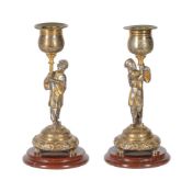 A PAIR OF FRENCH PARCEL GILT AND SILVERED FIGURAL CANDLESTICKS