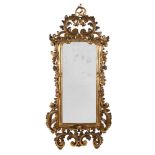 A CARVED GILTWOOD WALL MIRROR