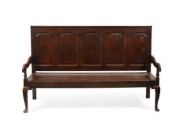 A GEORGE III OAK FIVE PANEL SETTLE