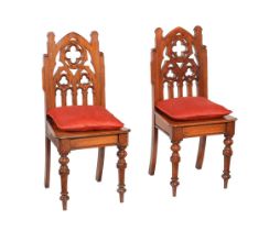 A PAIR OF VICTORIAN CARVED OAK HALL CHAIRS IN GOTHIC TASTE