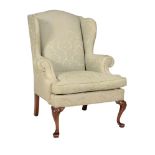 A MAHOGANY AND UPHOLSTERED WING ARMCHAIR IN GEORGE II STYLE