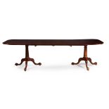 A MAHOGANY TWIN PILLAR DINING TABLE IN GEORGE III STYLE