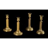 TWO PAIRS OF SIMILAR FRENCH GILT METAL CANDLESTICKS