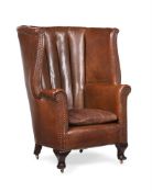 A LEATHER UPHOLSTERED WING ARMCHAIR, EARLY 20TH CENTURY