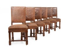A SET OF TWELVE VICTORIAN OAK AND CORDOBA LEATHER UPHOLSTERED CHAIRS, IN GOTHIC REVIVAL TASTE