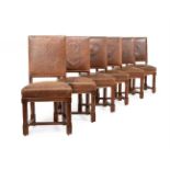 A SET OF TWELVE VICTORIAN OAK AND CORDOBA LEATHER UPHOLSTERED CHAIRS, IN GOTHIC REVIVAL TASTE