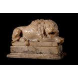 A 'GRAND TOUR' CARVED VARIEGATED ALABASTER MODEL OF A RECUMBENT LION, LATE 18TH/EARLY 19TH CENTURY