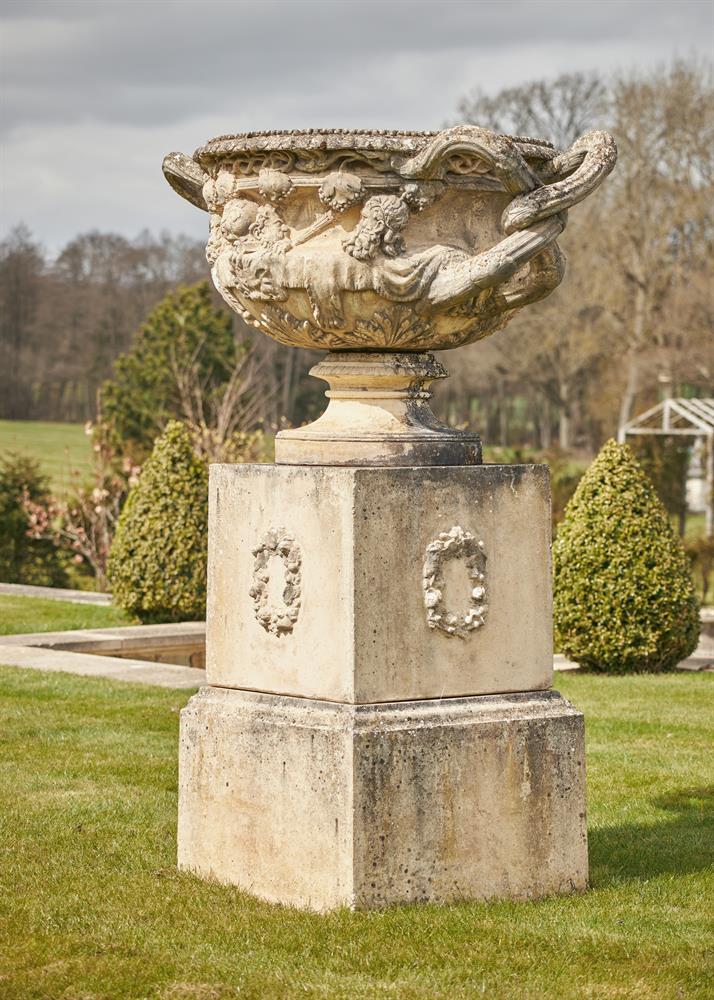 A LARGE CAST STONE WARWICK VASE AND PEDESTAL, IN THE MANNER OF COADE